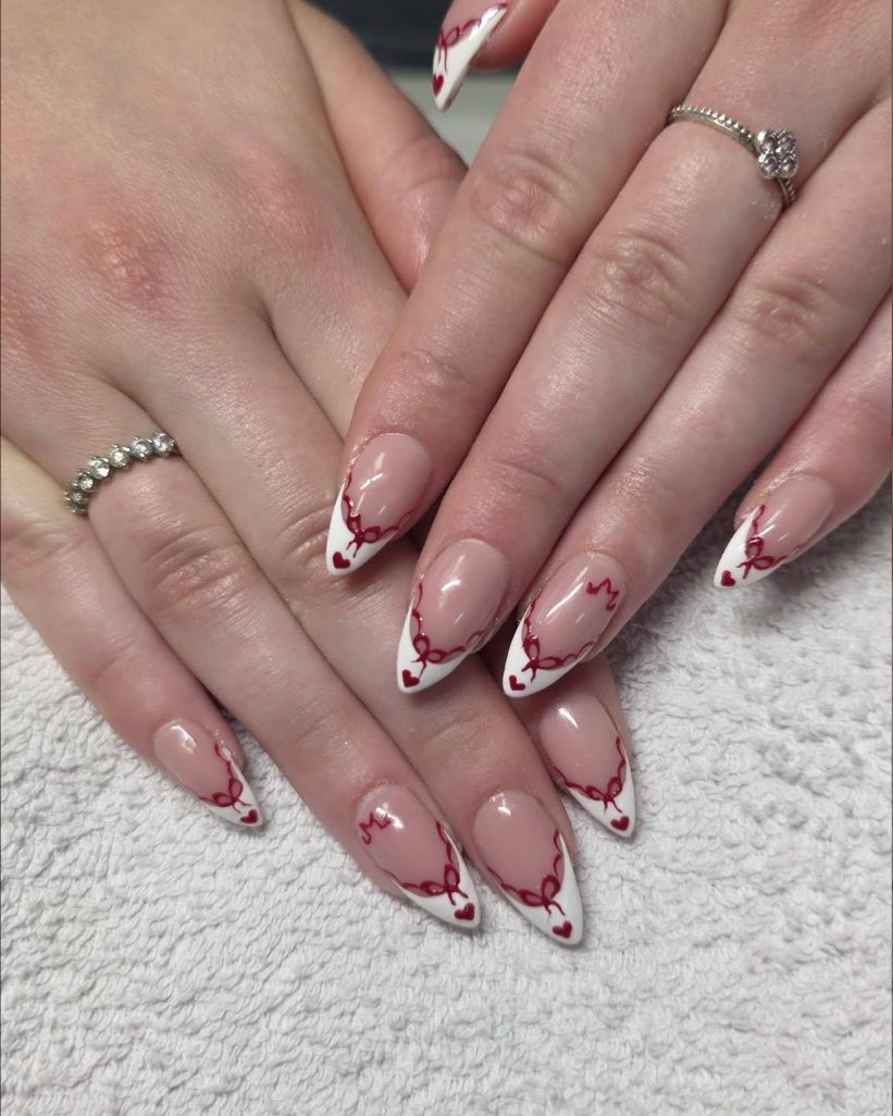 Almond nails with white tips, hand painted red ribbon bows and small red hearts