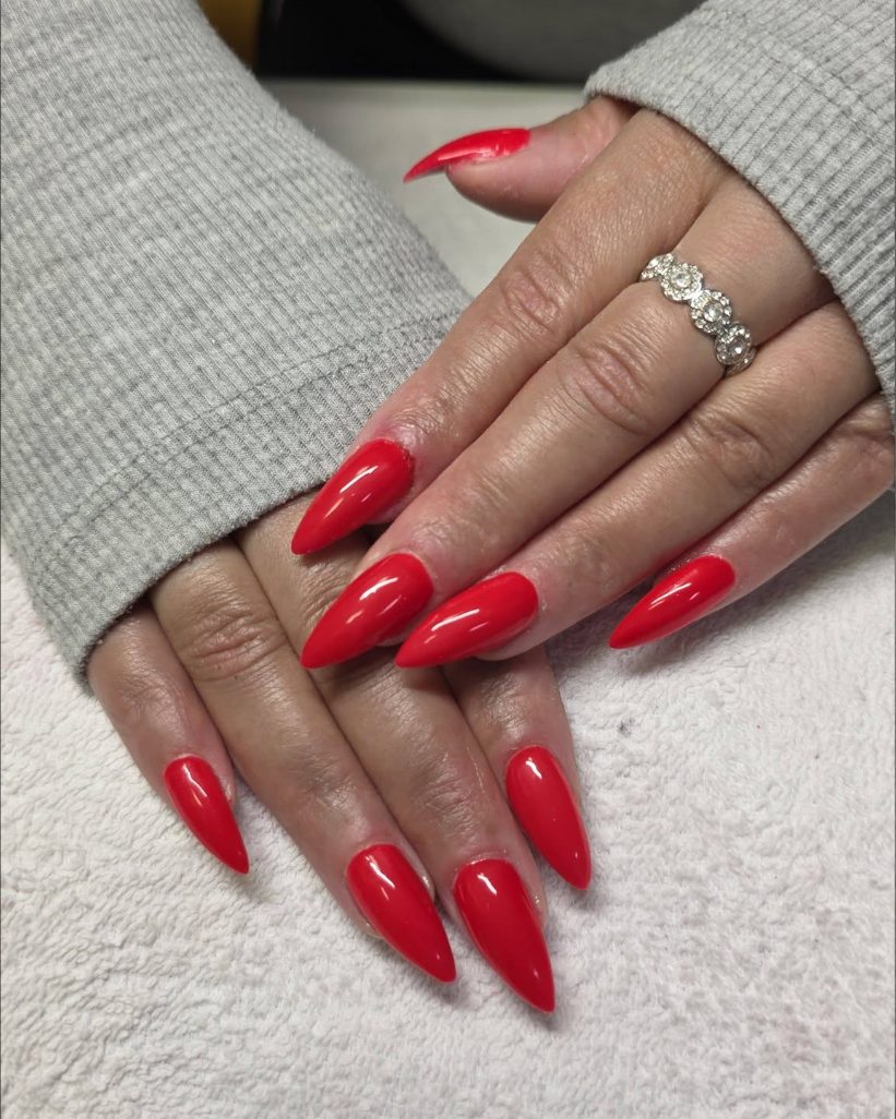 Long red stiletto nails in a high gloss gel
